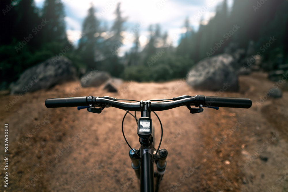 Embracing Freedom on Forest Trails with Mountain bike with air suspension fork. Bike POV handlebar.