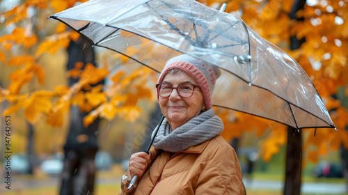 elderly woman under an umbrella in autumn photo