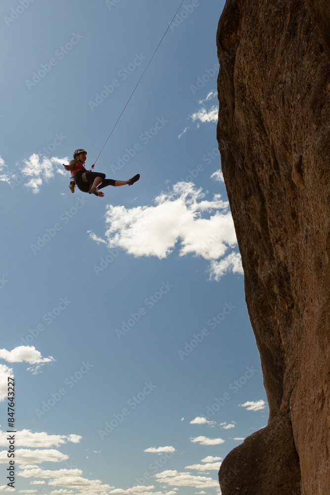 A man is hanging from a rope on a cliff A man is hanging from a rope on a cliff