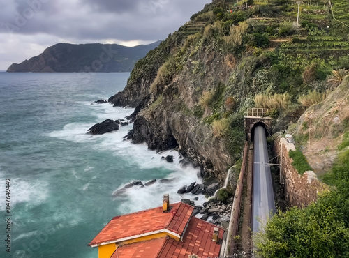 Long exposure blur of train going through tunnel next to sea in Italy. photo