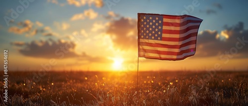 American flag waving in a field at sunset. photo