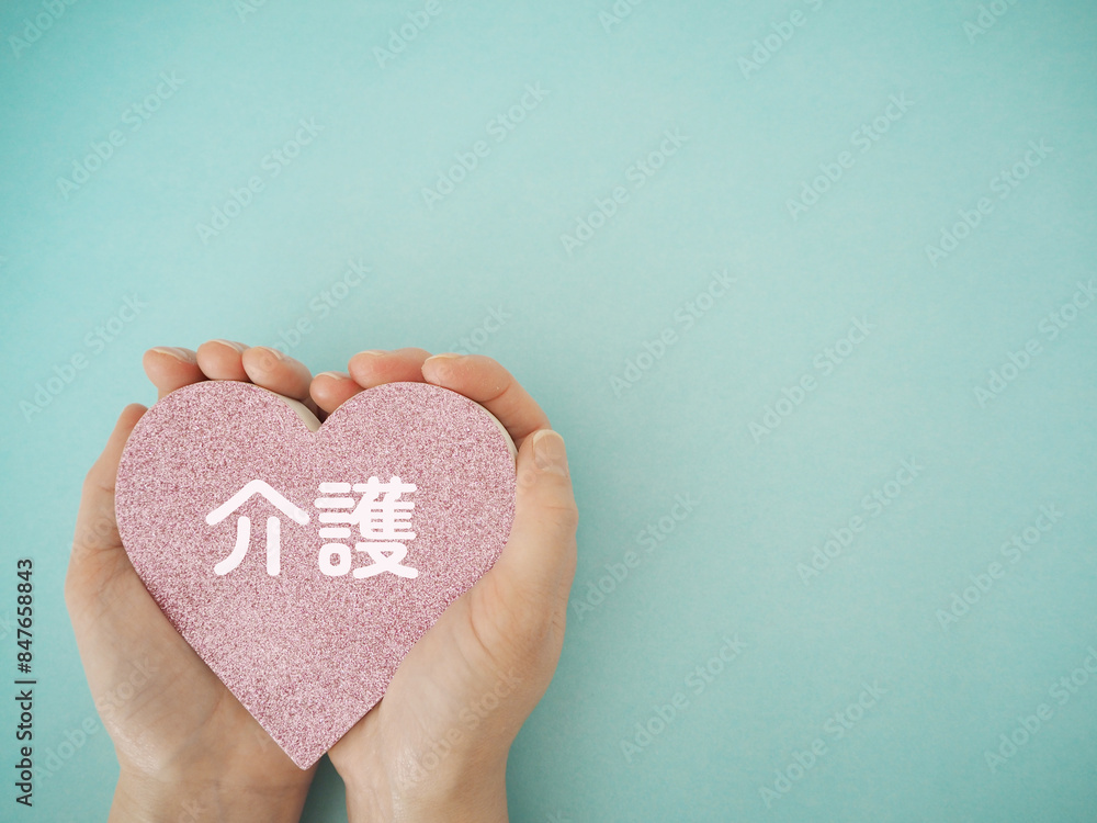 Fototapeta premium 手に持ったハートに介護の文字 コピースペース