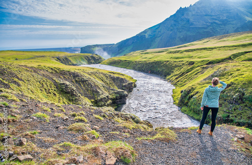 Woman exploring Hestavadsfoss waterfalls in summer season, Iceland photo