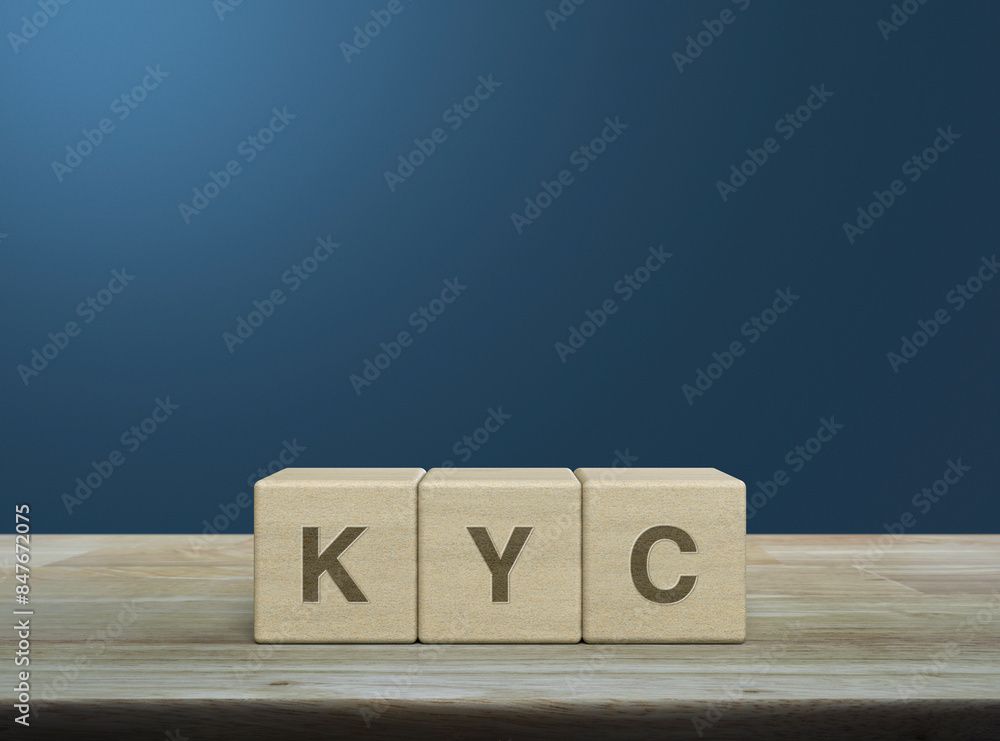 KYC acronym on wood block cubes on wooden table over light blue wall, Know your customer concept KYC acronym on wood block cubes on wooden table over light blue wall, Know your customer concept
