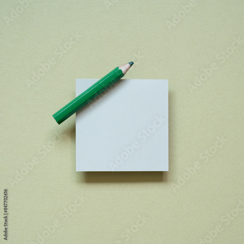 Obraz na płótnie Blank memo pad with green pencil on khaki desk background. top view w salonie