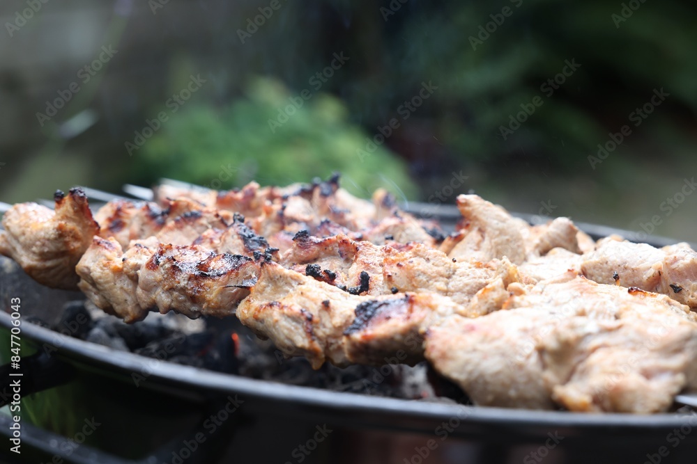 Cooking delicious kebab on metal brazier outdoors, closeup Cooking delicious kebab on metal brazier outdoors, closeup