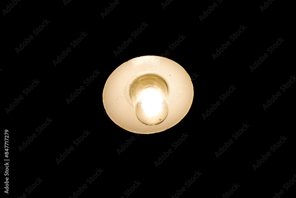 Light in the dark. Old lamp glows dimly against a black background.
Light in the dark. Old lamp glows dimly against a black background.
