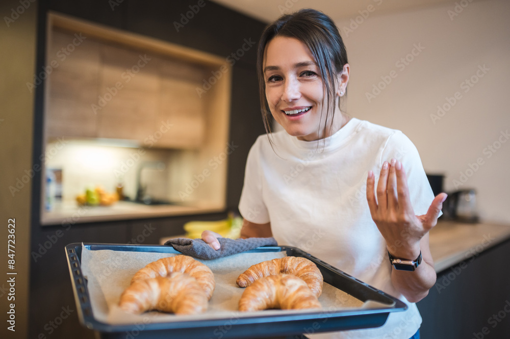 Young woman with a tray with fresh croissants Young woman with a tray with fresh croissants