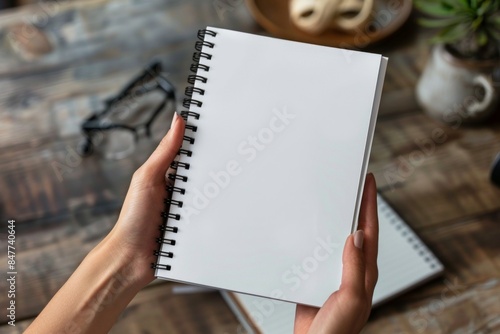 a woman holding a spiral notebook with black spirals