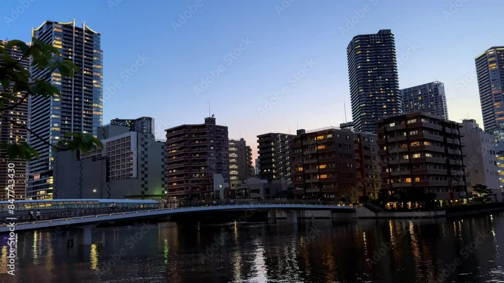 City skyline and bridge reflecting on a river at twilight City skyline and bridge reflecting on a river at twilight