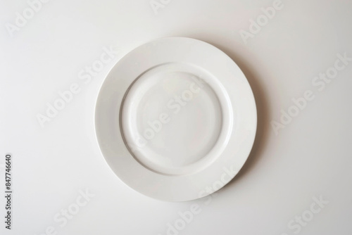 A single white plate centered on a plain white background, emphasizing simplicity and minimalism in its stark presentation.