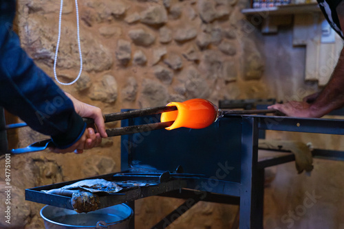 Artisans making a blown glass vase in a workshop photo