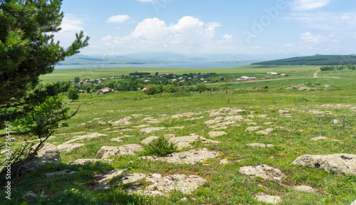 View of the village of Beshtasheni and the Tsalka reservoir from a stone hillock. Bright sky with clouds photo