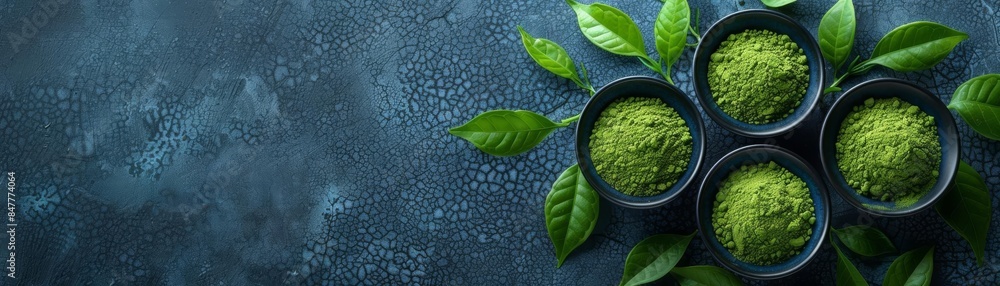 Fresh green matcha powder in bowls, surrounded by fresh leaves on a textured background, emphasizing natural health and wellness Fresh green matcha powder in bowls, surrounded by fresh leaves on a textured background, emphasizing natural health and wellness