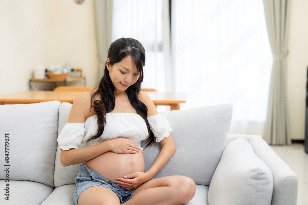 Pregnant woman look at her tummy at home Pregnant woman look at her tummy at home