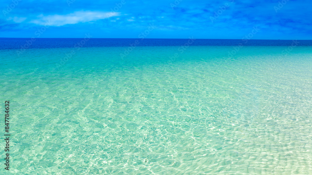 View of sandy beach for summer vacation concept. Nature of the beach and sea in summer with sunlight, and light sand. The sea sparkles against the blue sky. Sandy Beach for summer vacation concept View of sandy beach for summer vacation concept. Nature of the beach and sea in summer with sunlight, and light sand. The sea sparkles against the blue sky. Sandy Beach for summer vacation concept