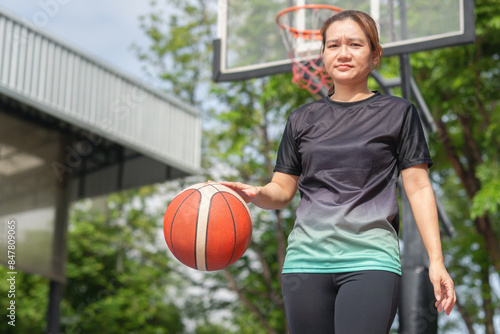 Active Asian woman playing basketball in the urban outdoor basketball court, Healthy life concepts