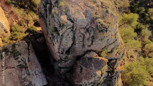 Man rock climbing aerial view of sportsman rapelling mountain in La Panocha, el Valle Murcia, Spain woman rapel down a mountain climbing a big rock photo