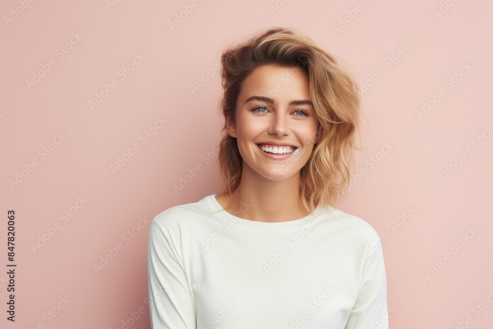 Portrait of a grinning woman in her 30s sporting a long-sleeved thermal undershirt isolated in pastel or soft colors background Portrait of a grinning woman in her 30s sporting a long-sleeved thermal undershirt isolated in pastel or soft colors background