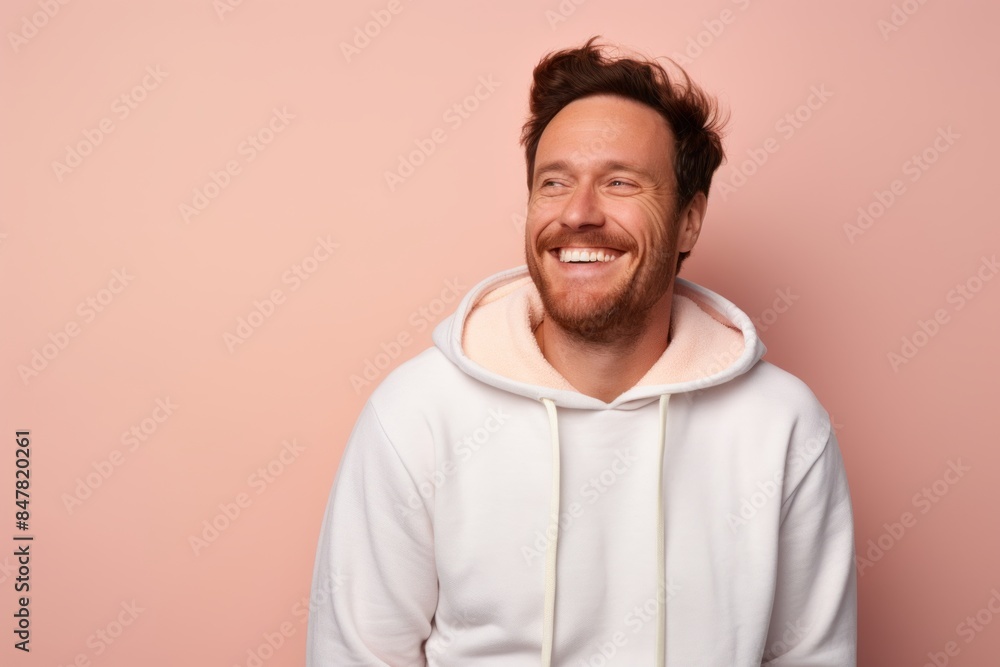 Portrait of a cheerful man in his 30s sporting a comfortable hoodie over pastel or soft colors background Portrait of a cheerful man in his 30s sporting a comfortable hoodie over pastel or soft colors background