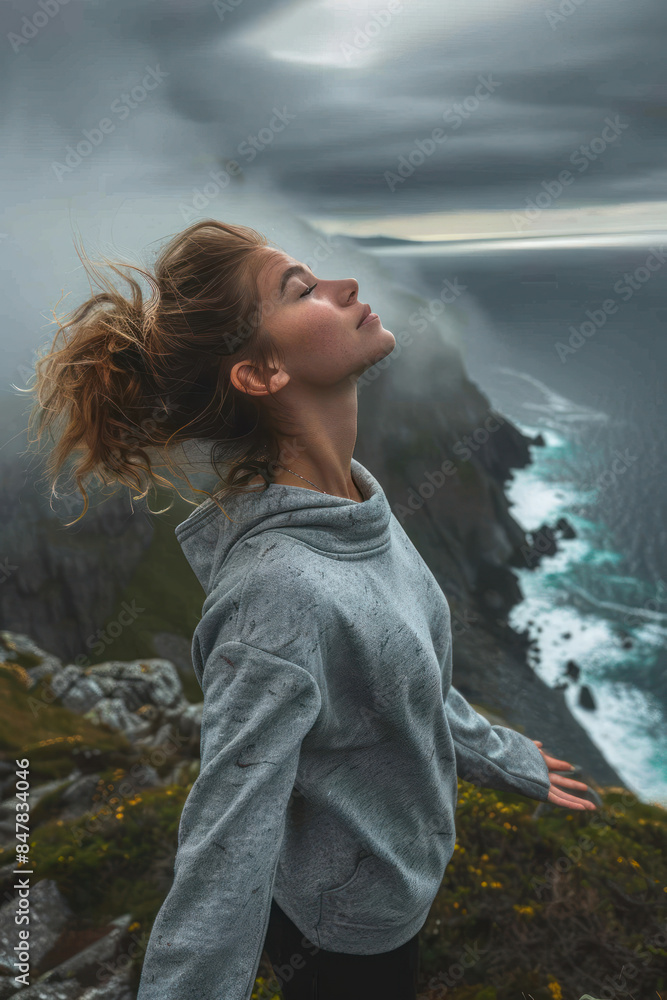 Serene Moment of Contemplation at the Edge of the World Woman in Gray Hoodie Enjoying the Ocean Breeze on a Misty Cliffside Day Serene Moment of Contemplation at the Edge of the World Woman in Gray Hoodie Enjoying the Ocean Breeze on a Misty Cliffside Day