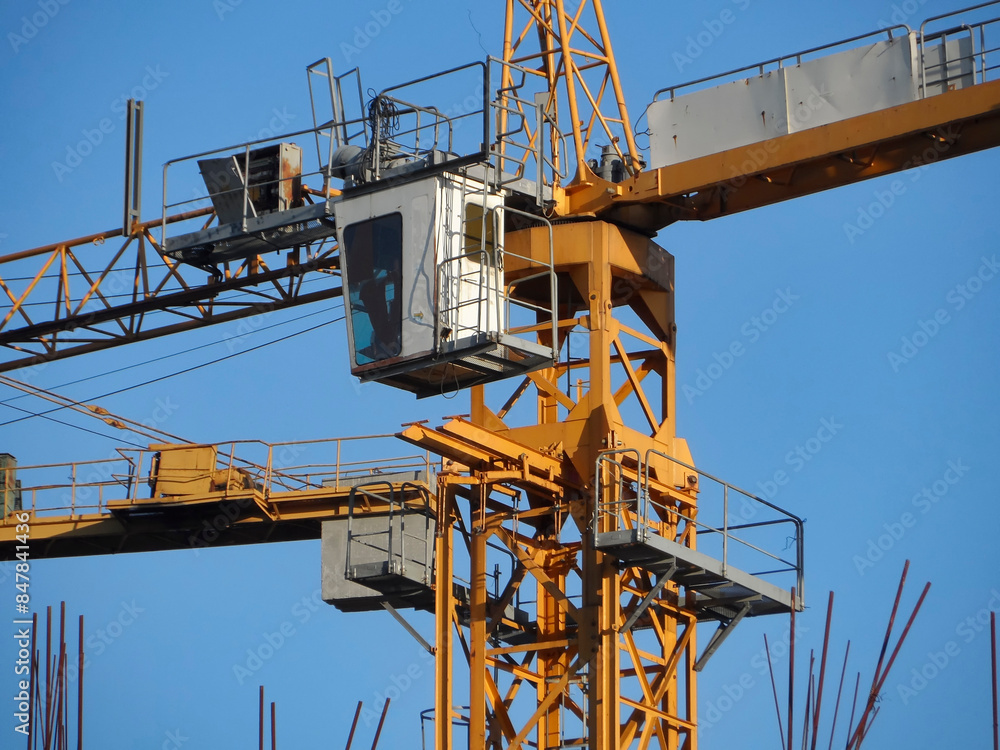 Yellow construction tower cranes against blue sky. Construction site. Architectural concept. Industry. Ust-Kamenogorsk (kazakhstan) Yellow construction tower cranes against blue sky. Construction site. Architectural concept. Industry. Ust-Kamenogorsk (kazakhstan)