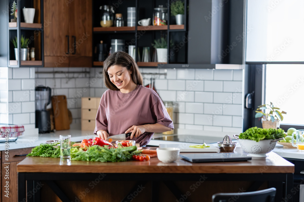 A young pretty cheerful woman is preparing a healthy various vegetable-based meal at home A young pretty cheerful woman is preparing a healthy various vegetable-based meal at home