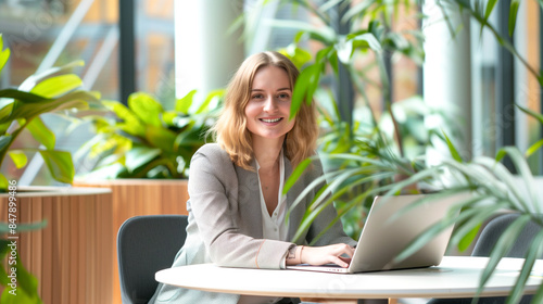 Russian female executive in a bright, open-plan office with plants and natural light