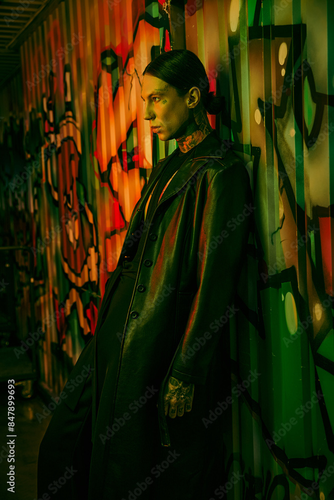 Naklejka premium A man next to a colorful graffiti-covered wall