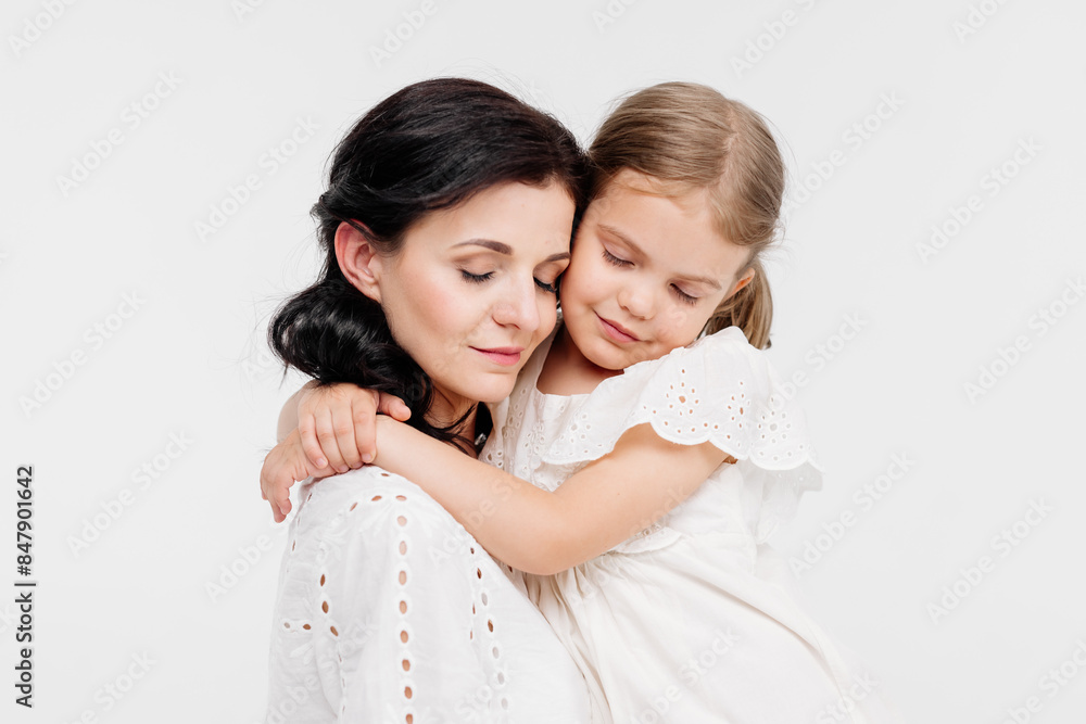 Close-up of a touching and gentle mother and daughter on a light background. Mom's tender touch. Family concept. Close-up of a touching and gentle mother and daughter on a light background. Mom's tender touch. Family concept.