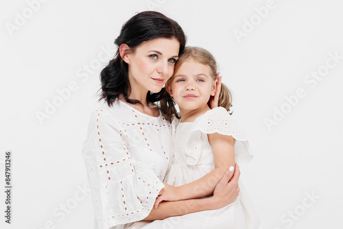 Close-up of a touching and gentle mother and daughter on a light background. Mom's tender touch. Family concept.