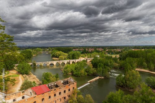 Urban landscape with Romanesque bridge over the Pisuerga river in Simancas, Valladolid, Spain. photo