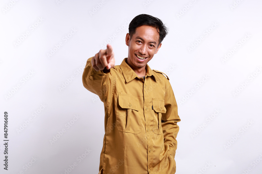 Smiling indonesian worker pointing to camera. Isolated on white