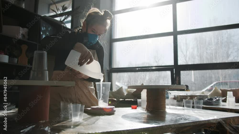 Artist's work involves using toxic liquids. The craftswoman must wear a respirator to protect herself from being poisoned by toxic fumes. Mid shot. Slow motion Artist's work involves using toxic liquids. The craftswoman must wear a respirator to protect herself from being poisoned by toxic fumes. Mid shot. Slow motion