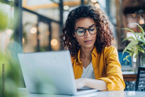 Young woman uses laptop to research information on the internet Mixed race woman sends email