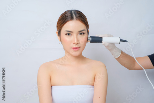 Beautiful Asian Woman Undergoing Treatment with RF Ultrasound Oxygeneo for Skin Care, skin tightening or contouring treatment. At a facial care, dermatologist or aesthetic clinic. photo