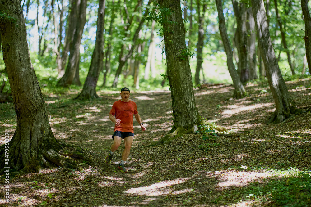 a strong middle-aged man running through the forest a strong middle-aged man running through the forest