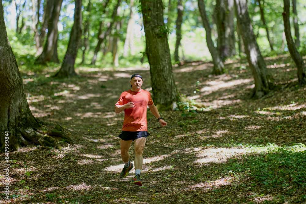 a strong middle-aged man running through the forest a strong middle-aged man running through the forest