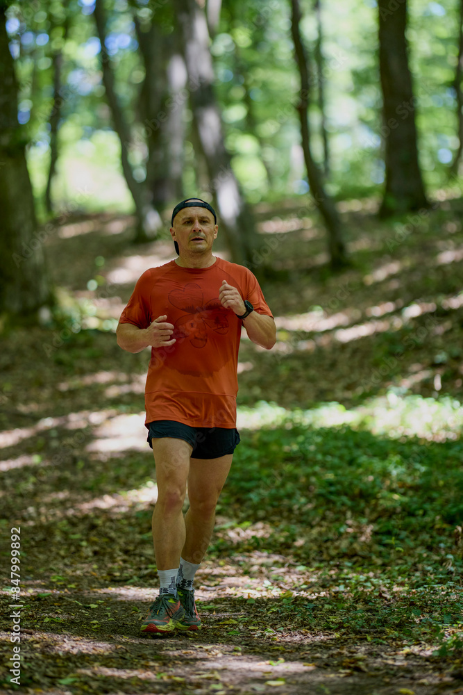 a strong middle-aged man running through the forest a strong middle-aged man running through the forest