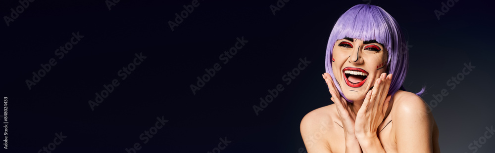 A pretty woman with purple hair and pop art makeup strikes a confident pose against a black background.