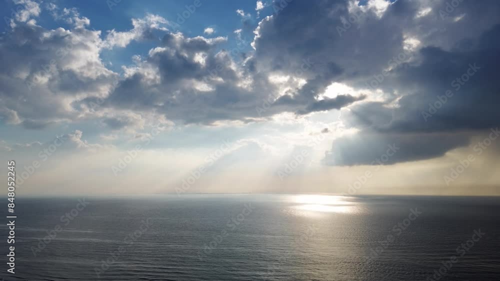 Beautiful sunset over the sea, ocean. Top view from a quadcopter. Beautiful flight. Ships and windmills on the horizon. The rays of the sun break through the clouds. Beautiful sunset over the sea, ocean. Top view from a quadcopter. Beautiful flight. Ships and windmills on the horizon. The rays of the sun break through the clouds.