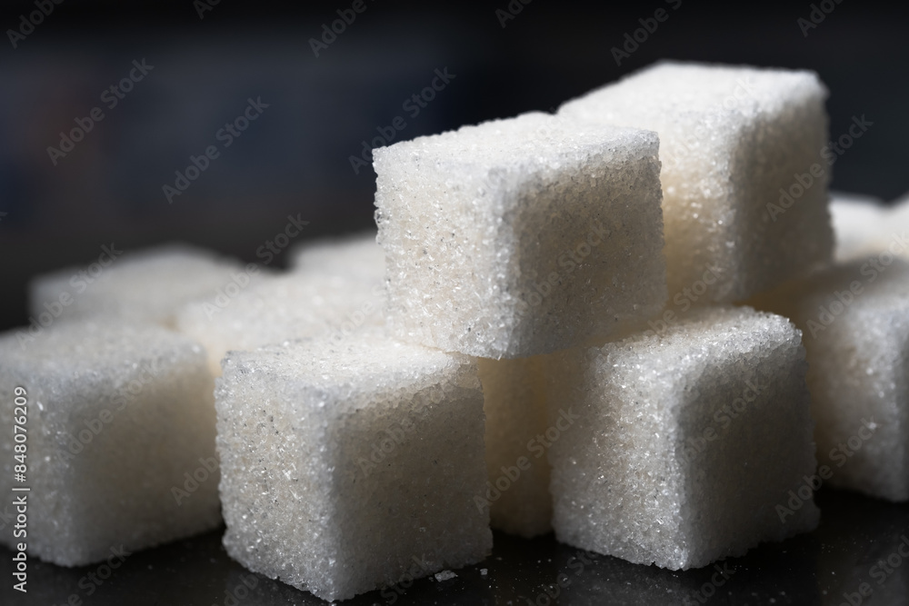 Pile of refined sugar cubes dark background. Pile of refined sugar cubes dark background.