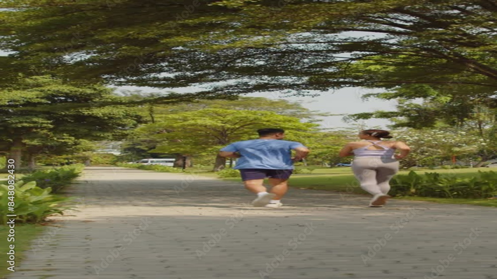 Vertical static shot of active people jogging in park together at sunny weather Vertical static shot of active people jogging in park together at sunny weather