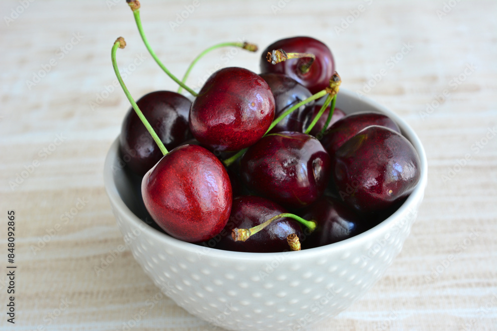 ripe cherries in a white bowl isolated close up ripe cherries in a white bowl isolated close up