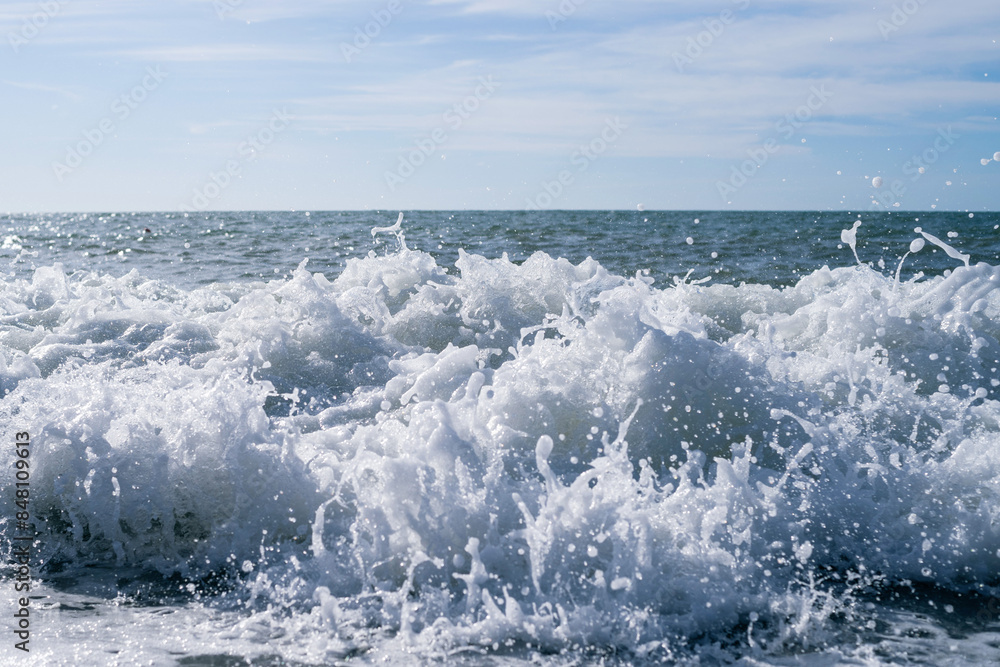 Sea wave close-up, water splash in the sea, sea foam against the sky on a summer sunny day Sea wave close-up, water splash in the sea, sea foam against the sky on a summer sunny day