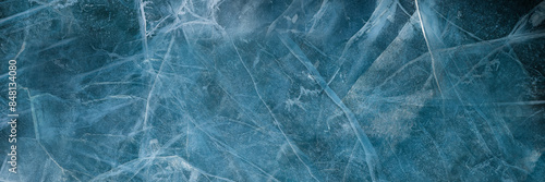 Abstract natural ice texture. Freezy ice surface. Blue backdrop with cracks and scratches on frozen water. Ice rink. Banner.