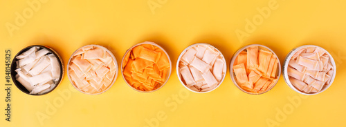 Bild auf Leinwand Multi-colored snus sachets with different flavors are placed in jars on a yellow background