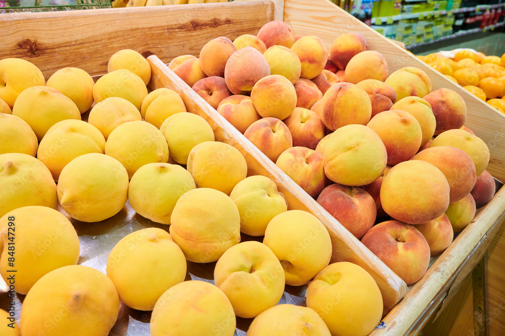 Two varieties of peaches displayed on fruit stands for sale at a local market. Two varieties of peaches displayed on fruit stands for sale at a local market.