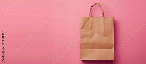Paper shopping bag on a pink background representing the concept of shopping sale and delivery. photo