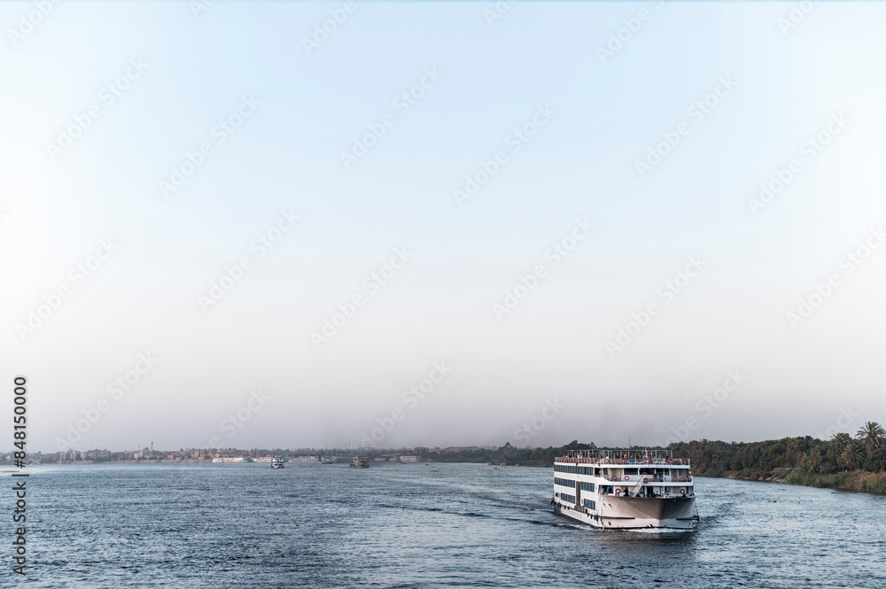 Large cruise boat on Nile River, calm water, scenic journey Large cruise boat on Nile River, calm water, scenic journey